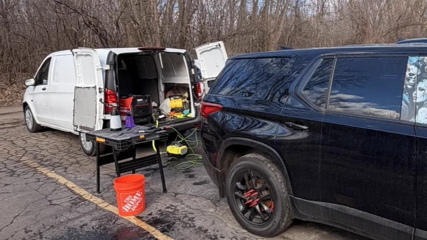 Self-contained mobile detailing rig beside a client vehicle
